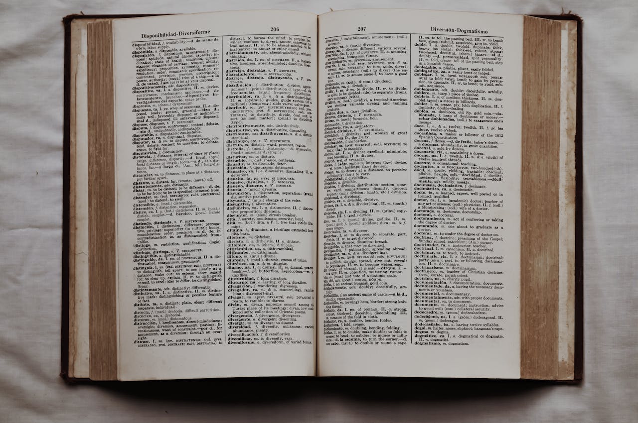 who-we-are Close-up of an open dictionary showing English and Spanish translations, flat lay view.