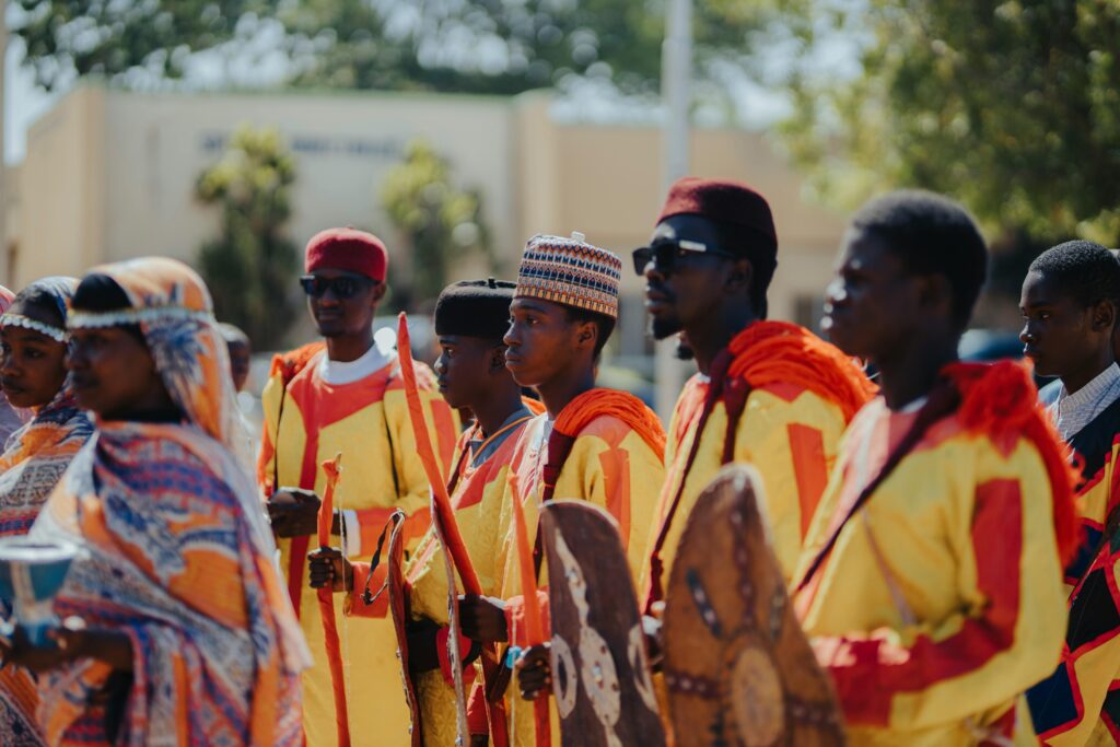 pexels-photo-34735560-34735560 A vibrant gathering of African people in traditional tribal attire at an outdoor festival.